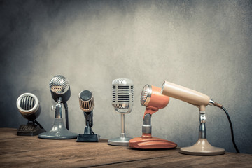 Retro old microphones for press conference or interview on the desk. Vintage style filtered photo