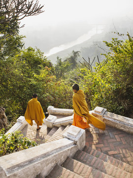 Monks walking down the stairs on the Ban Khamyong side of Mt. Phou Si..Luang Prabang, Laos.