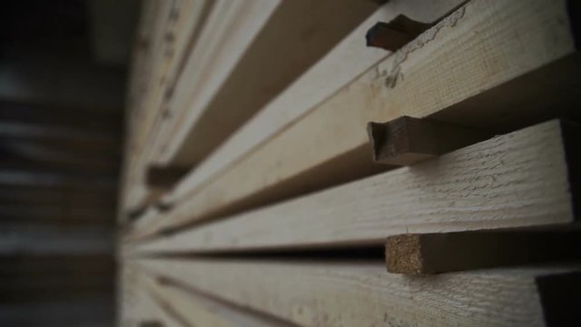 Storage timber. Lumber yard.Stock of timber wood construction in warehouse.Planks of wood stacked neatly on the shelves close up