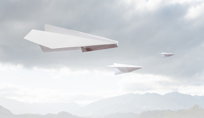 Naklejka na ściany i meble Origami plane flying in sky. Mixed media