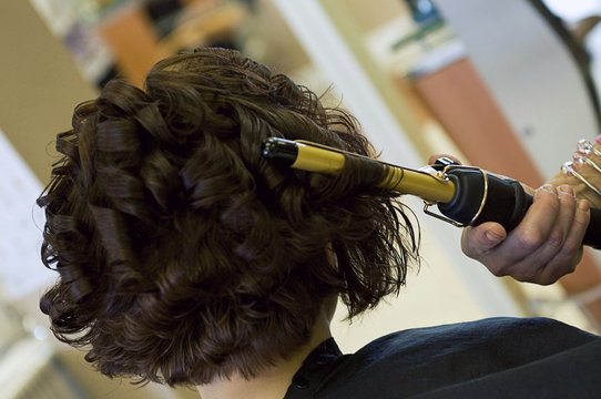 Hairdresser Curling Customer's Brown Hair