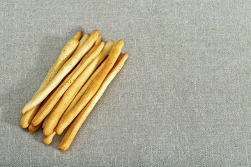 A bunch of breadsticks on linen cloth.