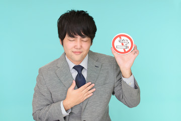 禁煙マークを持つ男性