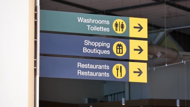 Motion of washroom, shopping and restaurants sign inside YVR airport 