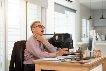 Obraz premium asian senior business man neck pain at work