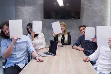 startup business team holding a white paper over face