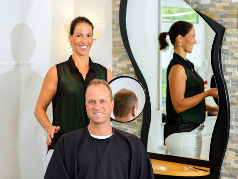 female hairdresser cutting hair of man