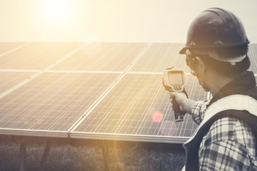 engineer checking heat of solar panel and using ir camera to scan heating of panel at solar power plant ; infrared camera using for checking and maintenance power plant of solar
