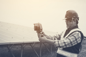 engineer checking heat of solar panel and using ir camera to scan heating of panel at solar power plant ; infrared camera using for checking and maintenance power plant of solar
