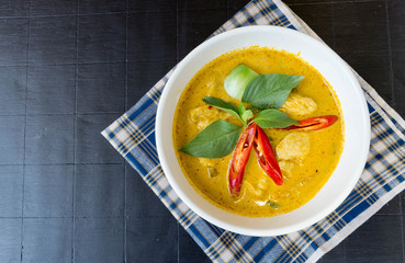 Green curry with chicken on dark wooden table top view. The popular food in Thailand.Thai food flat lay with copy space.