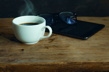 White cup of hot coffee on wooden table with copy space. Beginning the new working day in the morning with coffee. 