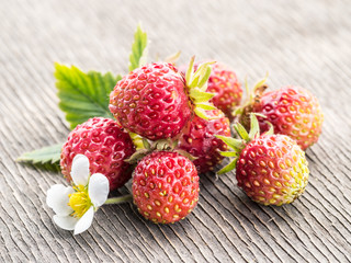 Wild strawberries on the wooden background.