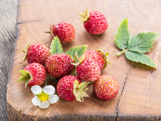 Wild strawberries on the wooden background.