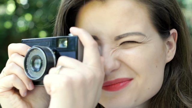Attractive woman doing photos on old vintage camera, steadycam shot
