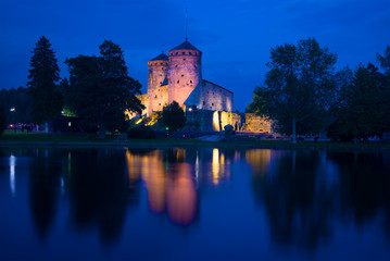 Obraz premium A view of the medieval Olavinlinna fortress of the blue August night. Savonlinna, Finland