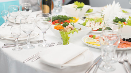 Served table in restaurant or cafe for a banquet, snacks and glasses for drinks