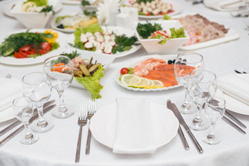 Served table in restaurant or cafe for a banquet, snacks and glasses for drinks