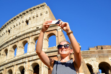 Happy girl making selfie in front of Colosseum in Rome, Italy.