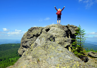 Girl on rock. Tourist on the top of Grosser Arber mountain in National park Bayerische Wald, Germany.