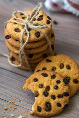 Honey cookies with raisins and milk on wooden table