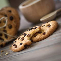 Honey cookies with raisins and milk on wooden table
