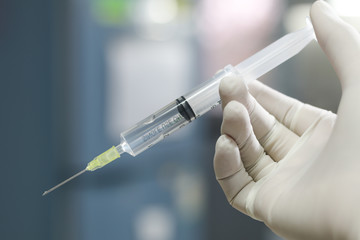 Syringe, medical injection Liquid narcotic in hand, palm or fingers. Medicine plastic vaccination vintage color.