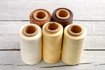Colorful wax cord, leather thread on white wooden background for leather crafting, wicker work and handcrafts.