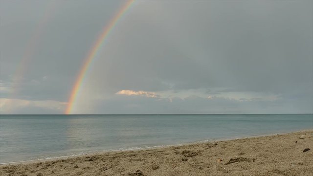 Seascape with rainbow from sand beach after rain in Greece, Platamon Olympus region 