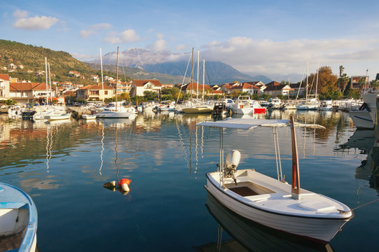 Fishing boats in harbor.  Marina Kalimanj  in Tivat town on a sunny autumn day with Lovcen mountain in the background. Montenegro