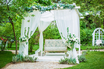 A beautiful white sofa is on the podium. alcove on the background of nature