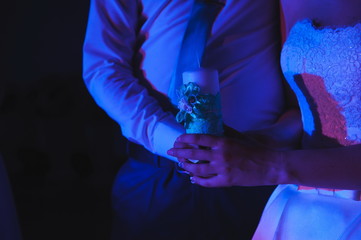 the bride and groom hold candles in their hands