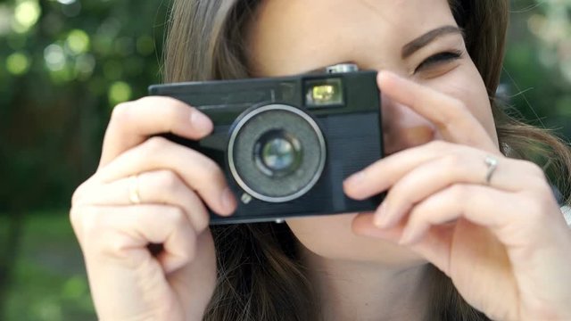 Attractive woman doing photos on old camera and looks happy, steadycam shot
