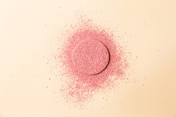 Powdered blush on a sponge on double background of pink and beige