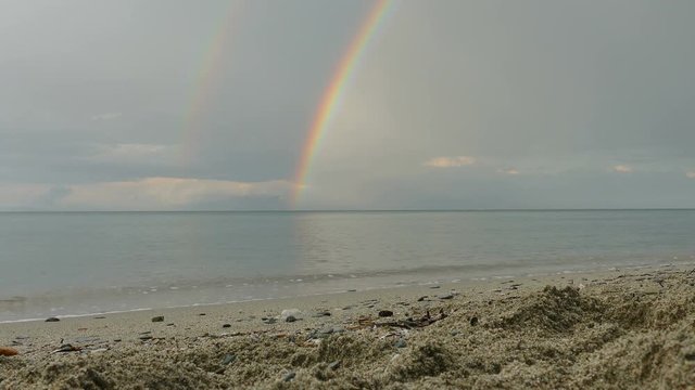 Seascape with rainbow and sand beach after rain in Greece, Platamon Olympus region