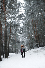 Two young teenage hipster girl friends together.Close up fashion portrait of two sisters hugs and having fun winter time,wearing sweater,best friends couple outdoors, snowy weather