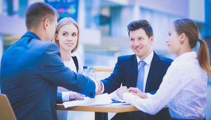 Group of happy young business people in a meeting at office