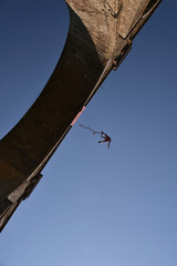 Obraz premium Seen from the ground bungee jumper falling down from a high stone bridge, Bunovo, Bulgaria