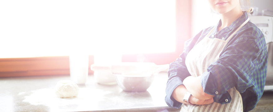 Beautiful Woman Cooking Cake In Kitchen Standing Near Desk