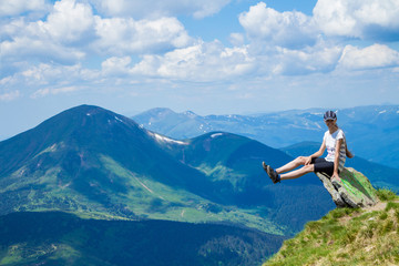 Young woman tourist on cliff`s edge of mountains enjoy the view. Travel and freedom concept
