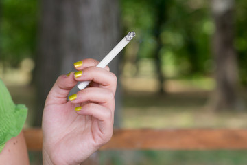 Woman smoking and holding a cigarette in a hand