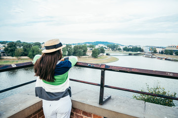 woman standing on the pier in the city and looking on the river