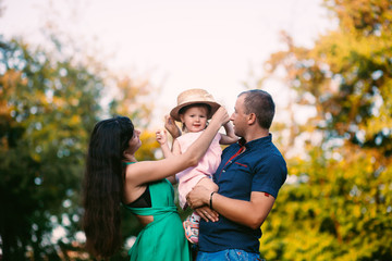 Fototapeta premium happy family concept - father, mother and child daughter having fun and playing in nature.