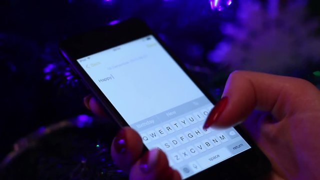 Young Woman Writing Sms In Front Of Christmas Tree - Powered by Adobe