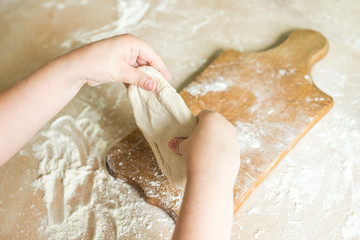 Children's hands make dough