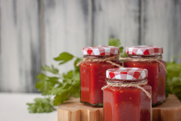 Three Caucasian tomato sauce jars on wood