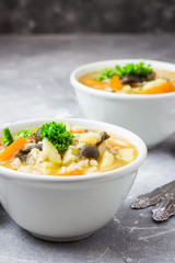 Creamy barley mushroom soup with vegetables and garlic. Spicy, winter comfort food. Selective focus, close up.