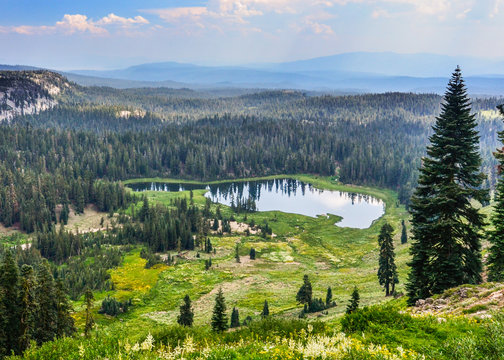 Aerial panoramic view of Crumbaugh  Lake at Lassen Volcanic National Park, California, USA, viewed from the trail to Bumpass Hell on a sunny, smoky day 