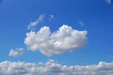 Naklejka na ściany i meble Fluffy white clouds on a blue sky.