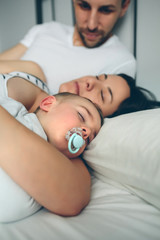Man looking at his wife and son sleeping
