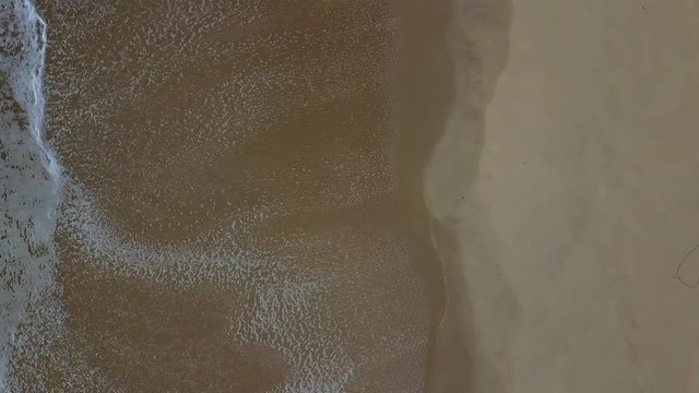 Aerial drone footage of sea waves crashing on shore.